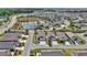 Community aerial view of houses, with a large pond in the background at 6223 Atkinson Ln, The Villages, FL 32163