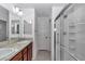 Well-lit bathroom with double vanity, shower, and large mirror at 6223 Atkinson Ln, The Villages, FL 32163
