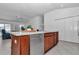 Bright kitchen features stainless steel dishwasher, wood cabinets, and a view to the living area at 6223 Atkinson Ln, The Villages, FL 32163