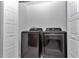 Modern laundry room with a black, front-loading washer and dryer and white paneled doors at 6223 Atkinson Ln, The Villages, FL 32163