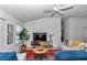 Bright living room featuring a modern rug, TV and entertainment console, with natural light from the window at 6223 Atkinson Ln, The Villages, FL 32163