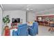 Bright living room featuring a ceiling fan, TV, comfortable seating, and an open layout to the kitchen at 6223 Atkinson Ln, The Villages, FL 32163