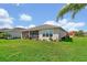 Well-maintained backyard featuring lush lawn, mature landscaping, and screened-in patio area at 634 Via Corso Ct, Kissimmee, FL 34759