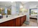 Bright bathroom featuring double sinks, granite counters, wood cabinets, and separate toilet and shower at 634 Via Corso Ct, Kissimmee, FL 34759