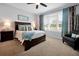 Comfortable bedroom featuring natural light, plantation shutters, and a cozy armchair at 634 Via Corso Ct, Kissimmee, FL 34759
