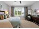 Bright bedroom with a serene view, plush bedding, and a stylish accent chair at 634 Via Corso Ct, Kissimmee, FL 34759