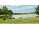 Scenic lake view surrounded by manicured lawn and mature trees and landscaping at 634 Via Corso Ct, Kissimmee, FL 34759