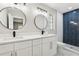 This bathroom features dual sinks, modern fixtures, and a tiled shower with a navy blue accent wall at 641 Peachwood Dr, Altamonte Springs, FL 32714