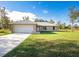 Charming single-story home with a two-car garage, lush lawn, and inviting curb appeal at 74 Malauka Pass, Ocklawaha, FL 32179