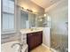 Bright bathroom with a walk-in shower and a separate soaking tub with gray stone details at 9942 Sweetleaf St, Orlando, FL 32827