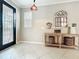 Light-filled foyer featuring tile flooring, a decorative mirror, and a glass-paneled front door at 9942 Sweetleaf St, Orlando, FL 32827