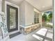 Covered front porch of home featuring stacked stone accents, a welcome sign, and decorative glass door at 9942 Sweetleaf St, Orlando, FL 32827