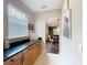Hallway with tile floors, granite counters, wood cabinets and view to dining room at 9942 Sweetleaf St, Orlando, FL 32827