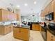 Bright kitchen with wood cabinetry, granite countertops, a center island, and an open view to the living area at 9942 Sweetleaf St, Orlando, FL 32827