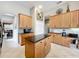 Spacious kitchen with wood cabinets, dark countertops, a central island, and an open layout at 9942 Sweetleaf St, Orlando, FL 32827