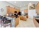 Open kitchen features a breakfast bar with stone accents, wood cabinets and tile floors at 9942 Sweetleaf St, Orlando, FL 32827