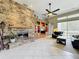 Living room with stone fireplace, tile floors, built-in entertainment center and ceiling fan at 9942 Sweetleaf St, Orlando, FL 32827