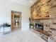 Living room with stone fireplace, tile floors, and hallway leading to other rooms at 9942 Sweetleaf St, Orlando, FL 32827
