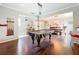 Open-concept living room with hardwood floors featuring a billiard table and seamless flow into the dining area at 9942 Sweetleaf St, Orlando, FL 32827