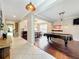 Open-concept living room featuring hardwood floors, a billiard table, and an entryway to the dining area at 9942 Sweetleaf St, Orlando, FL 32827