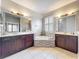 This primary bathroom features dual sinks, a soaking tub, and modern fixtures at 9942 Sweetleaf St, Orlando, FL 32827