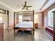 Spacious main bedroom with a four-poster bed, ceiling fan, and hardwood floors at 9942 Sweetleaf St, Orlando, FL 32827