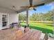 Covered patio with a fan, grill, dining set and view of the pond at 9942 Sweetleaf St, Orlando, FL 32827