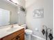 This powder room features a wood vanity, toilet, and decorative wall art at 9942 Sweetleaf St, Orlando, FL 32827