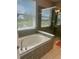 The bathroom features a modern soaking tub with a beautiful view from the adjacent window for natural light at 15708 Orange Harvest Loop, Winter Garden, FL 34787