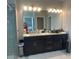 This bathroom features a black vanity with ample storage and a large mirror with great lighting at 15708 Orange Harvest Loop, Winter Garden, FL 34787