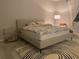 Bright bedroom with comfortable bed, stylish rug, glass side table and soft natural light from window at 15708 Orange Harvest Loop, Winter Garden, FL 34787
