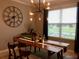 Elegant dining room with modern lighting fixture, a large clock, and a neatly set table at 15708 Orange Harvest Loop, Winter Garden, FL 34787