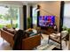 Bright living room featuring a modern leather sofa, stylish decor, and a view of the outdoor landscape at 15708 Orange Harvest Loop, Winter Garden, FL 34787