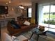 Comfortable living room with a modern kitchen and a view of the landscaped yard at 15708 Orange Harvest Loop, Winter Garden, FL 34787