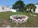 Backyard featuring a fire pit, shed, and lanai at 1100 Peak Cir, Deltona, FL 32738