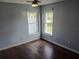 Bright bedroom featuring hardwood floors, two windows, and a ceiling fan at 1100 Peak Cir, Deltona, FL 32738