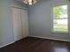 Bedroom with light blue walls, wood floors, a closet and a window at 1100 Peak Cir, Deltona, FL 32738