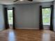 Bedroom features laminate flooring and large windows dressed with drapes overlooking the lawn at 1100 Peak Cir, Deltona, FL 32738