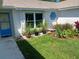 Landscaped front yard with a blue door and unique window at 1100 Peak Cir, Deltona, FL 32738