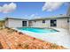 Backyard pool area featuring a pool and adjacent brick patio and garden at 116 7Th St, Winter Haven, FL 33880