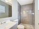 Bathroom featuring a tiled glass shower, gray walls, modern vanity, and updated fixtures at 116 7Th St, Winter Haven, FL 33880