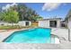 A sparkling pool is bordered by a garden, storage shed, and a patio at 116 7Th St, Winter Haven, FL 33880