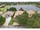Aerial view of a home with a tile roof, manicured lawn, mature landscaping, and a water view at 1266 Saint Albans Loop, Lake Mary, FL 32746