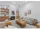 Cozy living room featuring a stone fireplace, built-in shelving, comfortable seating, and a modern chandelier at 1266 Saint Albans Loop, Lake Mary, FL 32746