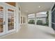 Covered patio features white columns, double French doors, and serene views of lush landscaping and the adjacent property at 1266 Saint Albans Loop, Lake Mary, FL 32746