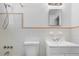 Well-maintained bathroom featuring a white vanity, toilet, tiled walls, and a shower head, exuding cleanliness at 1340 Continental Dr, Daytona Beach, FL 32117