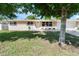 Charming single-story home featuring a well-maintained lawn, a brick accent, and mature shade trees at 1340 Continental Dr, Daytona Beach, FL 32117