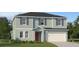 Charming two-story home featuring light blue siding, gray shutters, and a two-car garage at 1365 Inkberry Cir, Deland, FL 32720