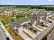 Aerial view of townhomes, a playground, a pond, and a green space on a sunny day at 1555 Dawnview Way, Kissimmee, FL 34744