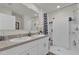 Bathroom featuring a double sink vanity, large mirror, and walk-in shower with decorative curtain at 1555 Dawnview Way, Kissimmee, FL 34744